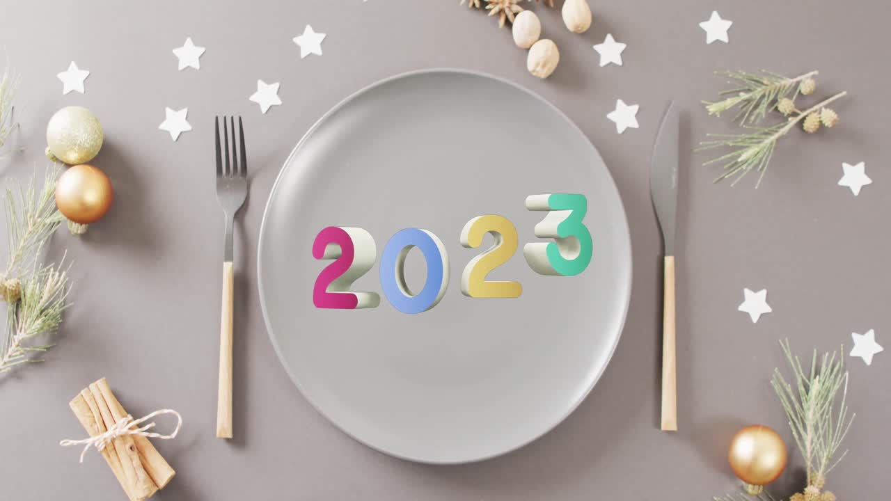 Animazione della scritta 2023, posto tavola natalizio e decorazioni sullo sfondo