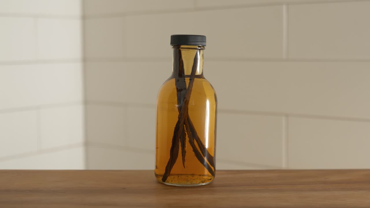 mano poniendo una botella de extracto de vainilla casero