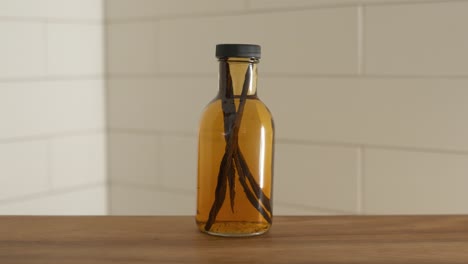 mano poniendo una botella de extracto de vainilla casero