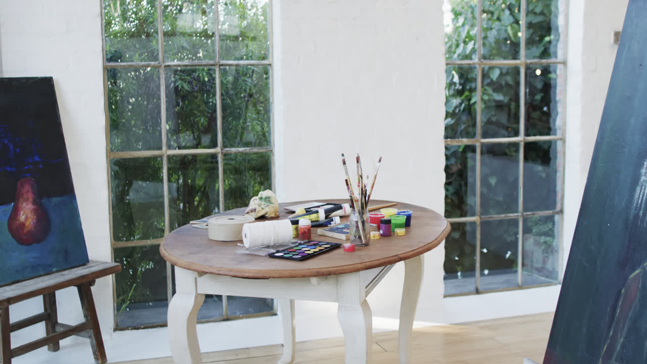 스튜디오에서 테이블 위에 있는 그림과 페인트와 질의 클로즈업, 슬로우 모션