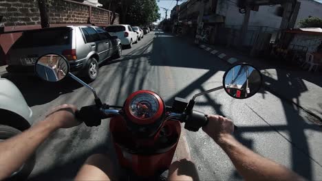 pov man driving moped through streets of chiang mai, thailand