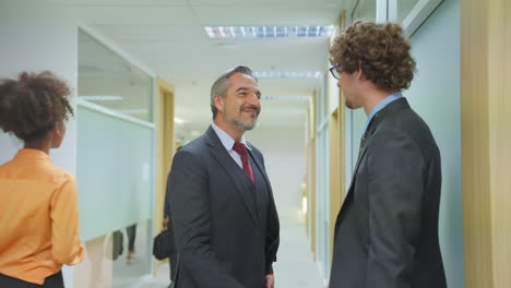 businessmen meeting in office corridor