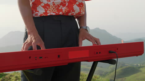 cerca de la cintura y las manos de un hombre tocando el piano afuera