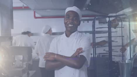 Animation-of-african-american-male-chef-smiling-in-kitchen-over-light-spots