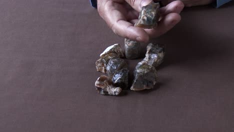 a gemologist inspecting a parcel of rough and rare african cat's eye opal, close up