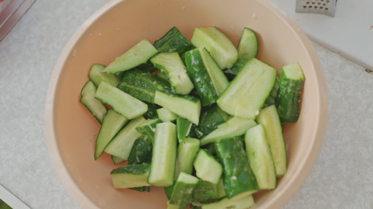 Insalata verde brillante croccante sul tavolo. Pezzi di cetriolo preparati per una veloce esperienza culinaria all'aperto. Fette di cetriolo colorate e fresche, splendidamente disposte per il servizio immediato all'aperto.
