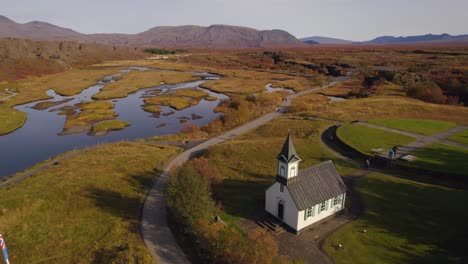 drone approaching black icelandic church of thingvellir in autumn season