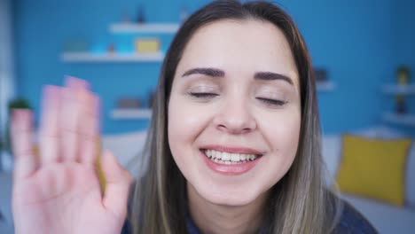 Cute-young-woman-waving-at-camera.