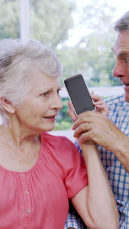 surprised senior couple using smartphone