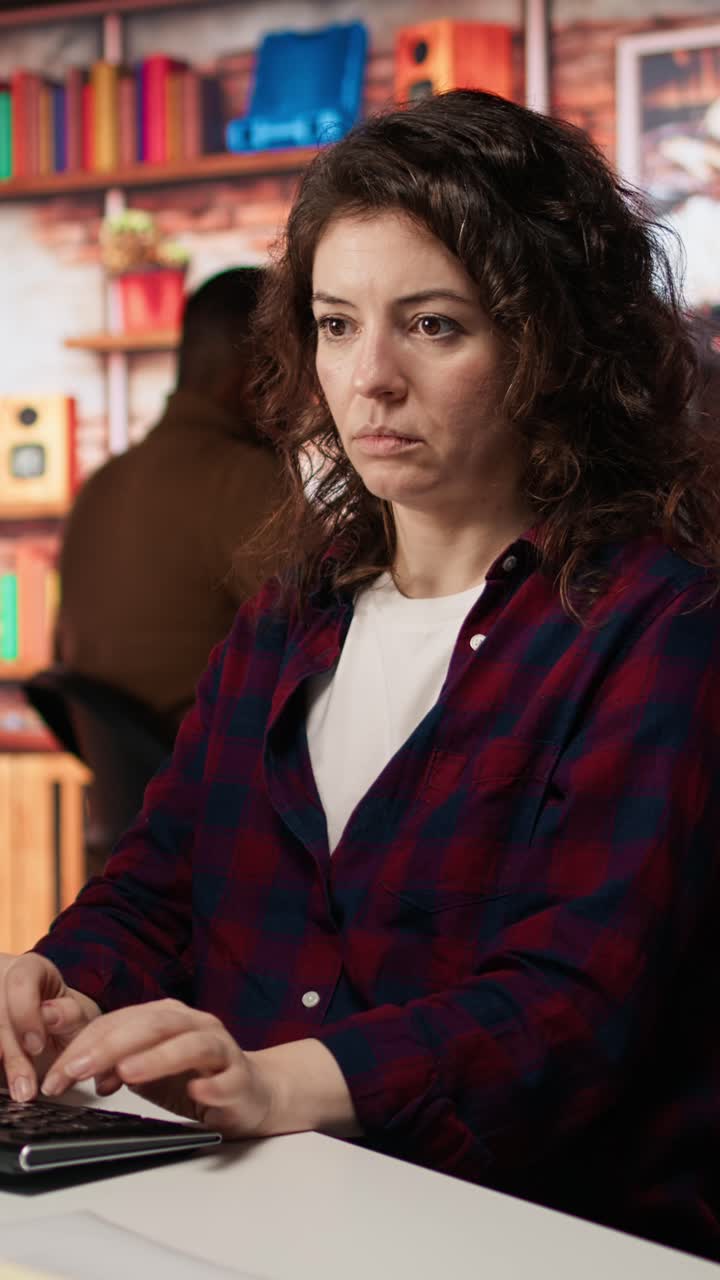 Vertical video Woman using PC in startup office to design and implement algorithms