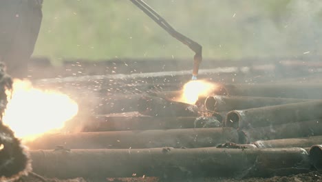 torcher cutting metal in slow motion at a scrapyard, big power tools 120fps