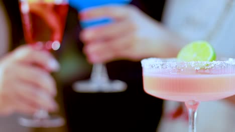 colorful cocktails raised in a lively atmosphere, highlighting a festive and social mood with vibrant drinks and cheerful interactions