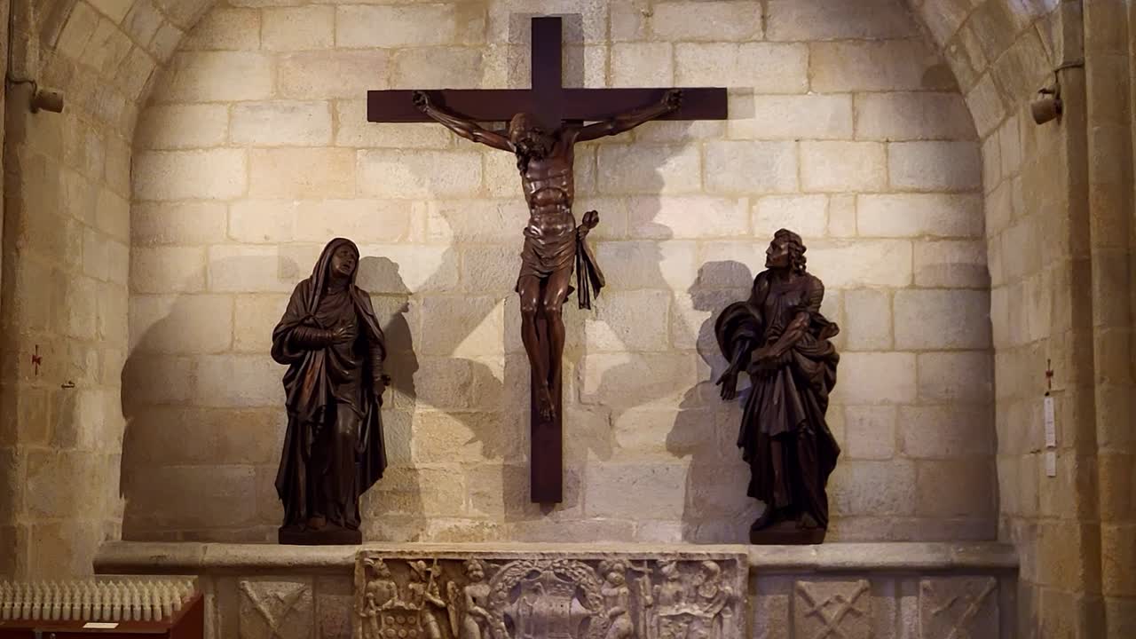 Christ crucified, Virgin Mary and Mary Magdalene. 15th-century wood carving. Catholic religious art. Cáceres Cathedral. Spain
