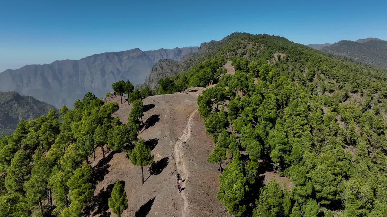 Aerial View of Hikers on a Mountain Path in a Lush Green Forest