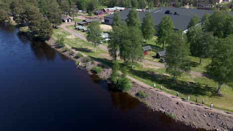 reversed drone footage revealing a group of runners, running alongside of a river in dalarna sweden