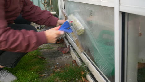 a female cleaning a window of a home in sweden - close up