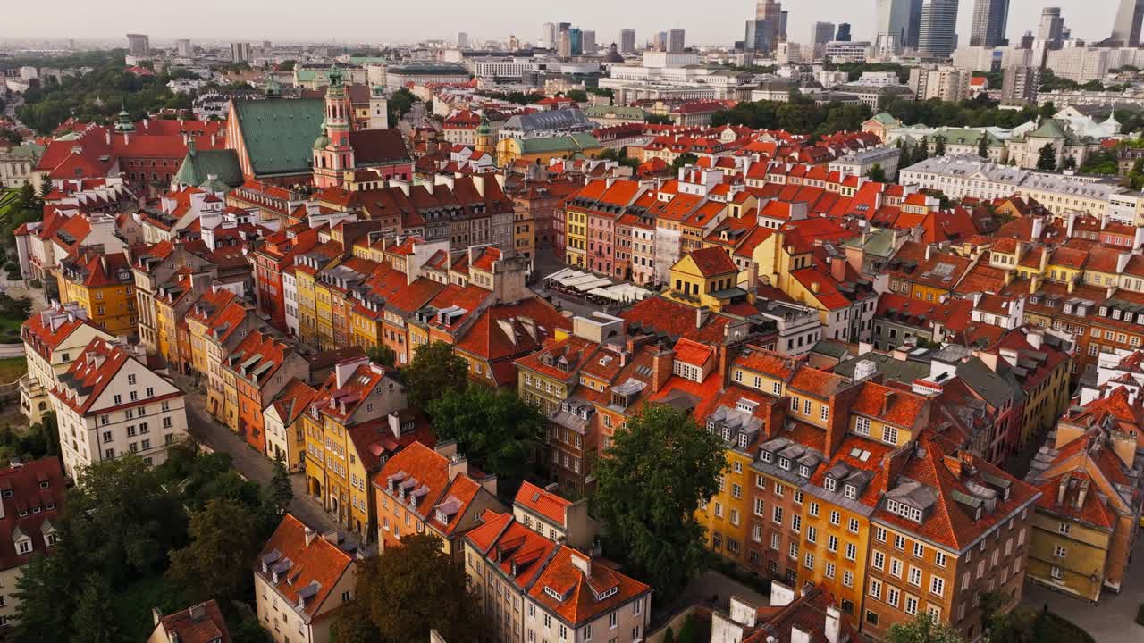 Drone pull back from Warsaw Old Town rooftops to reveal modern skyline view