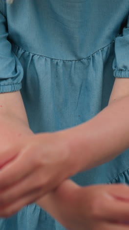 se ve a una madre sosteniendo dos conos de helado, sus manos cruzadas mientras se prepara para dar las golosinas a sus hijos, con los niños recogiéndolas de ella