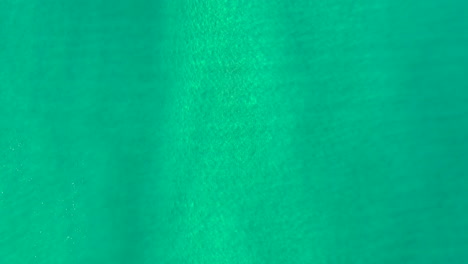 downward drone shot of beautiful ocean waters and surf