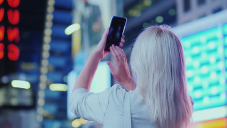 retrato de una mujer atractiva tomando fotografías de lugares de interés en times square se encuentra en el fondo