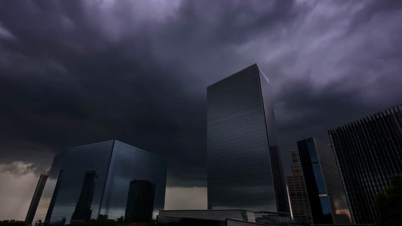 Time lapse di nuvole temporalesche scure che si muovono sopra grattacieli di città moderne