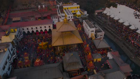 Imágenes-De-Drones-De-La-Hora-Dorada-Del-Templo-Pashupatinath-De-Katmandú-En-Shivaratri-Muestran-Impresionantes-Vistas-Aéreas-Del-Antiguo-Templo-Y-Sus-Alrededores,-Capturando-La-Esencia-Espiritual-Del-Momento