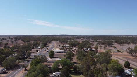 Drone-Despegando-En-Un-Pequeño-Pueblo-Mostrando-Una-Carretera-Que-Pasa-Con-Un-Automóvil