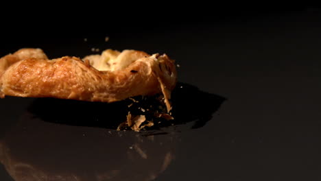 pastry snack falling on black background