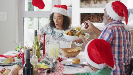 Feliz-Familia-Multigeneración-Afroamericana-Con-Gorros-De-Papá-Noel-Y-Celebrando-En-La-Cocina