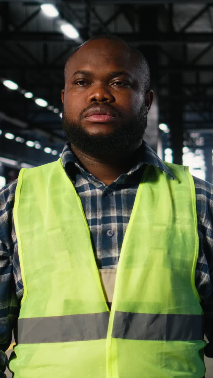 Vertical Video African american plant engineer stands near steel machinery during construction