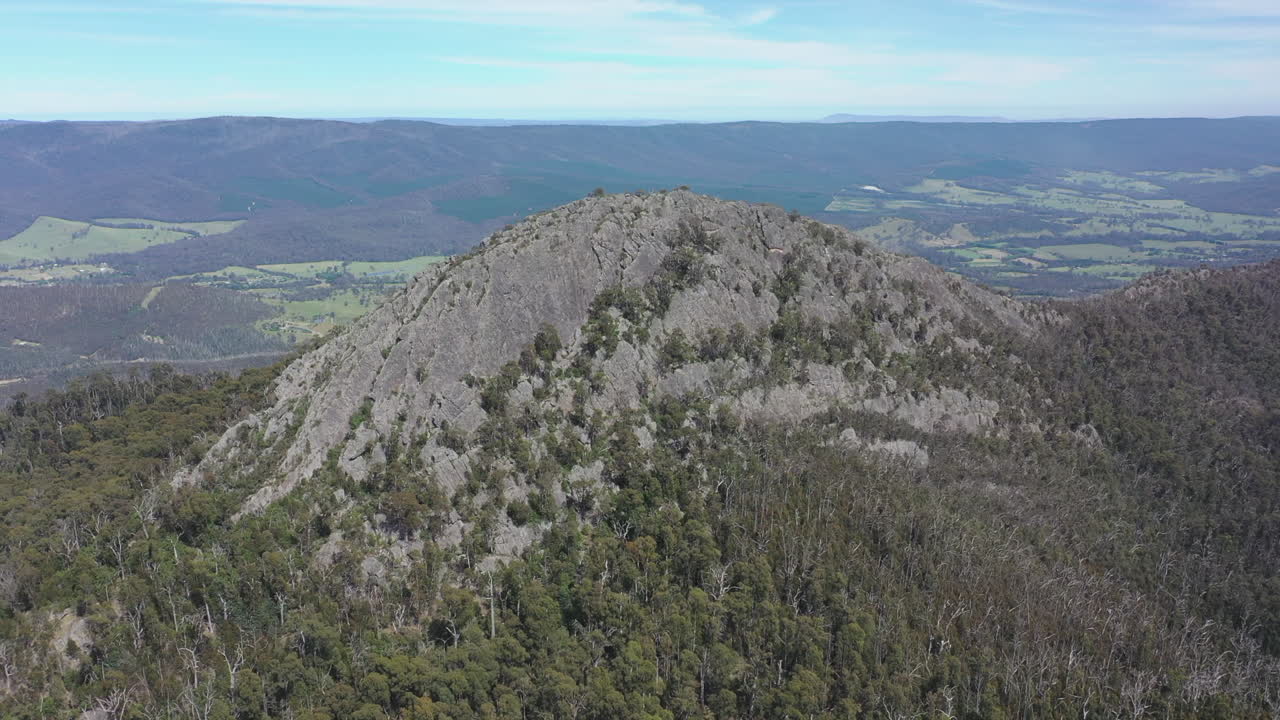 울퉁불퉁한 불모의 슈가로프 봉우리가 주변 계곡 위로 뚜렷하게 솟아 있습니다.