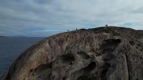 People-on-top-of-high-rocky-cliff,-Coast-of-Cape-Le-Grand,-Western-Australia