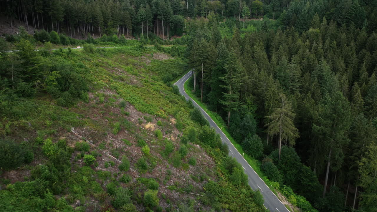 Aerial view approaching a empty mountain, forest road, on a dark evening
