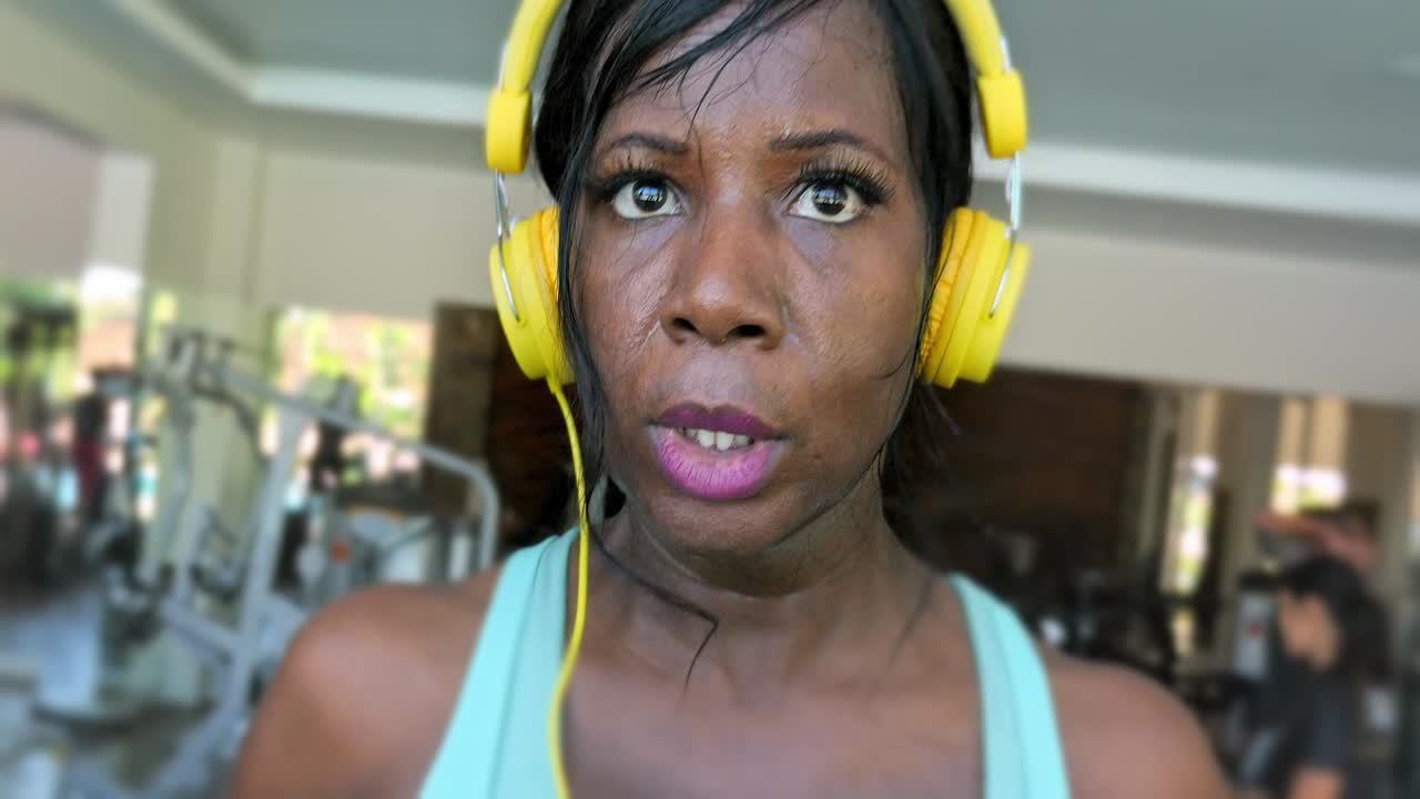 young attractive fit and athletic afro american black woman running on treadmill at gym fitness club in sweaty indoors workout