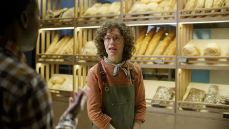 woman baker helping customer in bakery