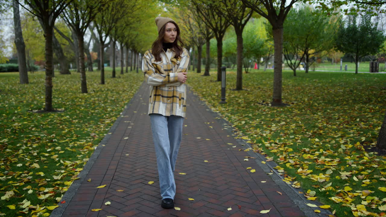 Stylish young woman having a walk in autumn park