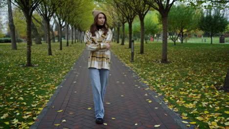 Stylish-young-woman-having-a-walk-in-autumn-park