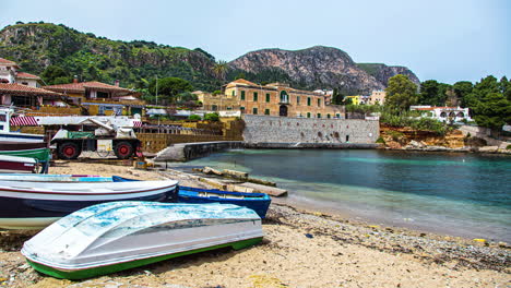 Vista-De-Los-Barcos-Atracados-En-El-Puerto-De-Bagnera-En-La-Localidad-De-Porticello-Cerca-De-Palermo-En-Sicilia,-Italia-Rodeado-De-Casas-Residenciales-Sobre-Terreno-Montañoso-Durante-El-Día-En-Timelapse