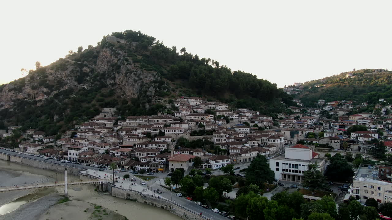 berat, la ciudad de las mil ventanas: vista aérea de las famosas casas albanesas y sus ventanas y el puente de gorica durante la puesta de sol