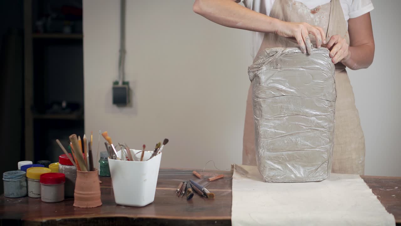 mujer trabajando con arcilla en el estudio de cerámica