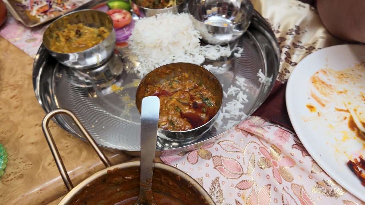 Overhead view of traditional Indian curry and rice served on a metal platter in Bangkok.