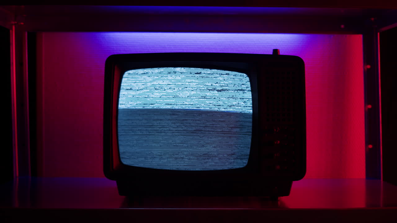 A retro TV displaying static noise, creating a nostalgic vintage atmosphere with blue and green hues.