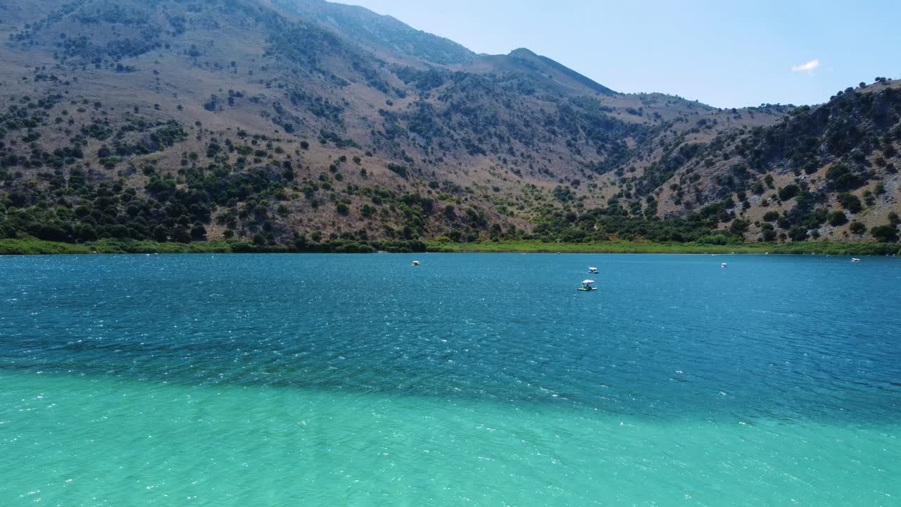 volar sobre el lago kournas con aguas turquesas y barcos de pedales, creta, grecia