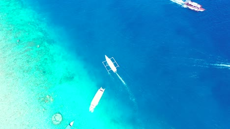 Boats-sailing-across-blue-turquoise-water-of-tropical-island-shoreline-with-vivid-colors-of-calm-lagoon-in-Philippines