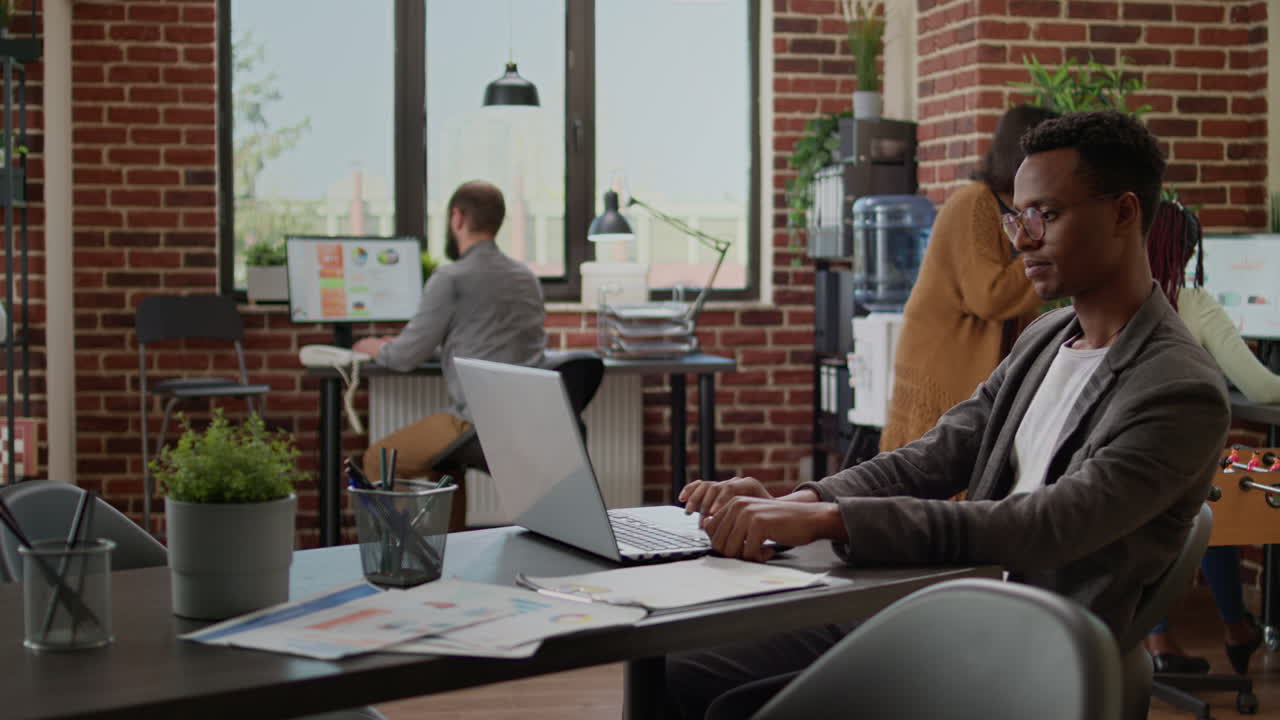 Office worker using laptop to send paperwork email