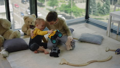 two siblings hugging in children room. nice brothers sitting on floor at home.