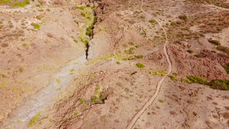 Dried-river-near-pathway,-Tenerife,-aerial-jib-shot