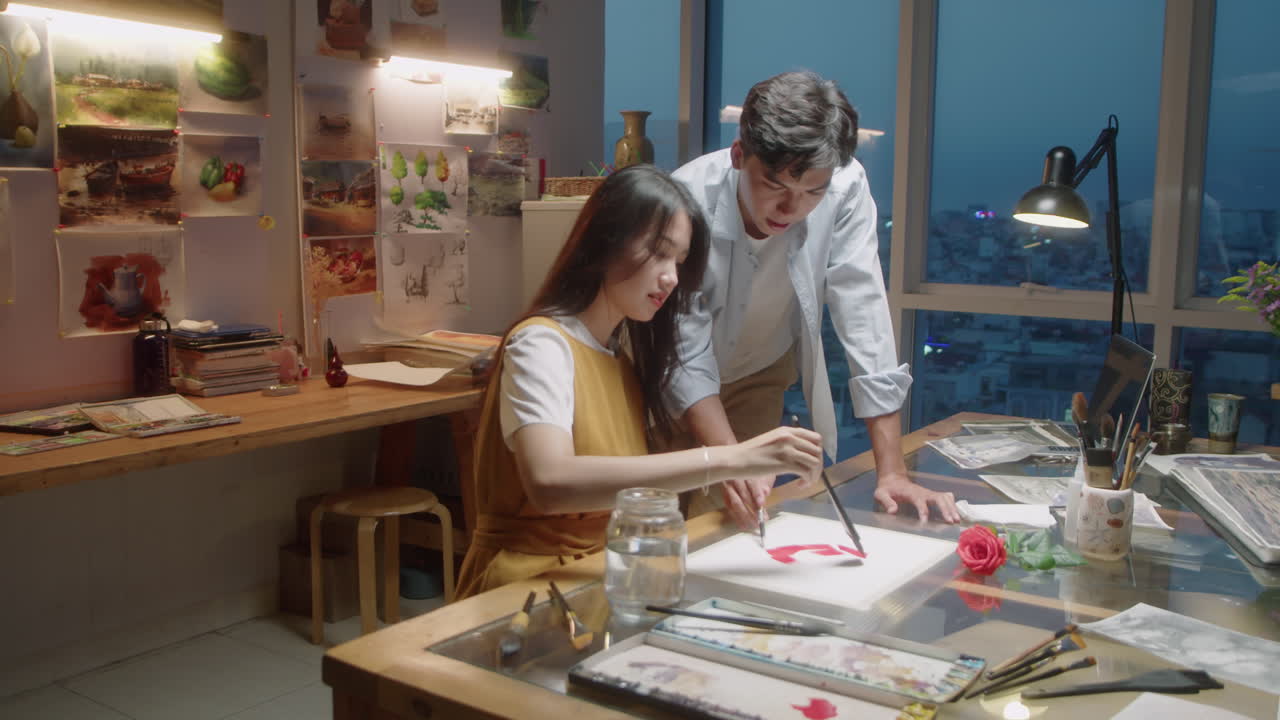 Asian Woman Painting Picture with Teacher in Art School