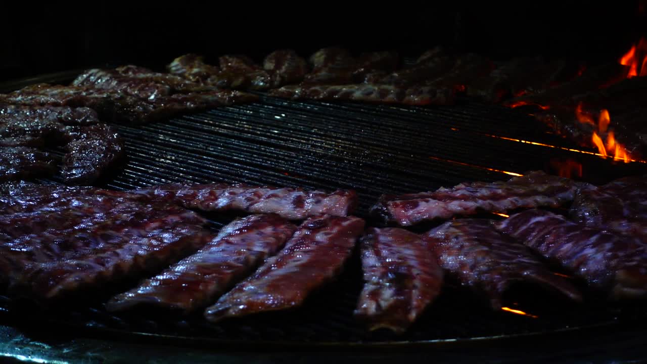 Costine di maiale che arrostiscono sul fuoco, barbecue. Rallentatore