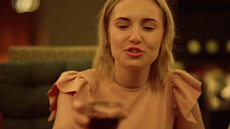 Woman-sitting-at-dining-table.-Laughing-girl-toasting-with-glass-of-wine